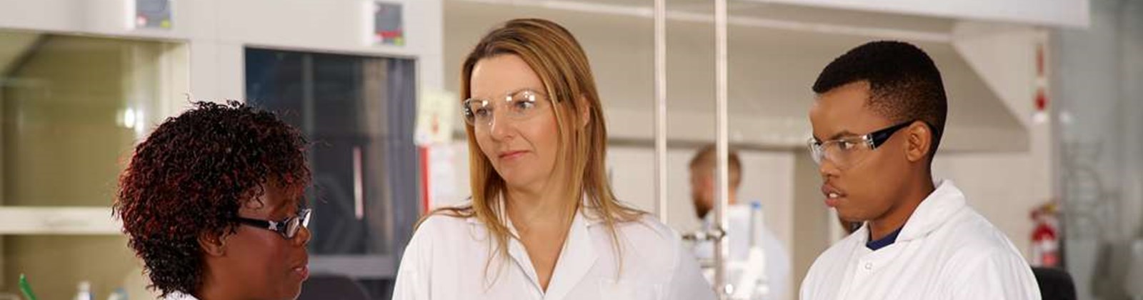 Three scientists talking in a lab in Cape Town, South Africa