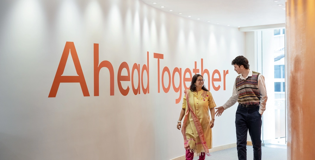 Deux employés marchent un couloir et discutent