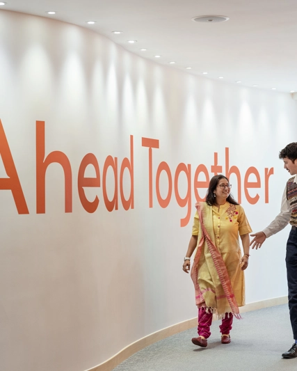 Deux employés marchent un couloir et discutent