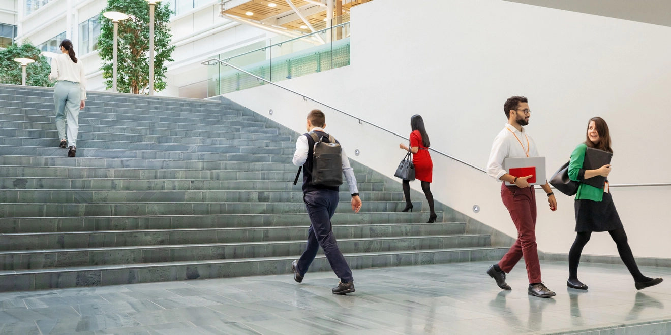 Employees walking up and down the stairs in front of a building
