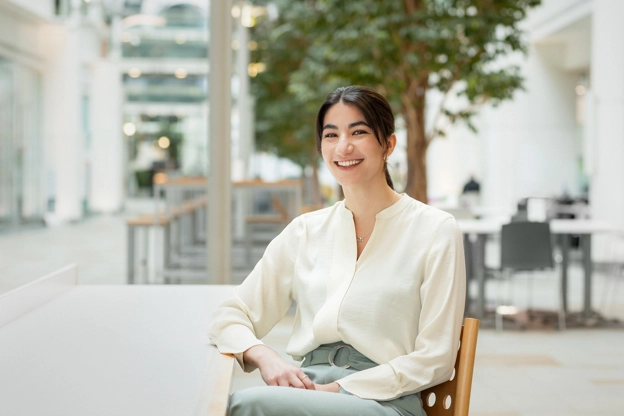 Woman posing and smiling while sitting on a chair